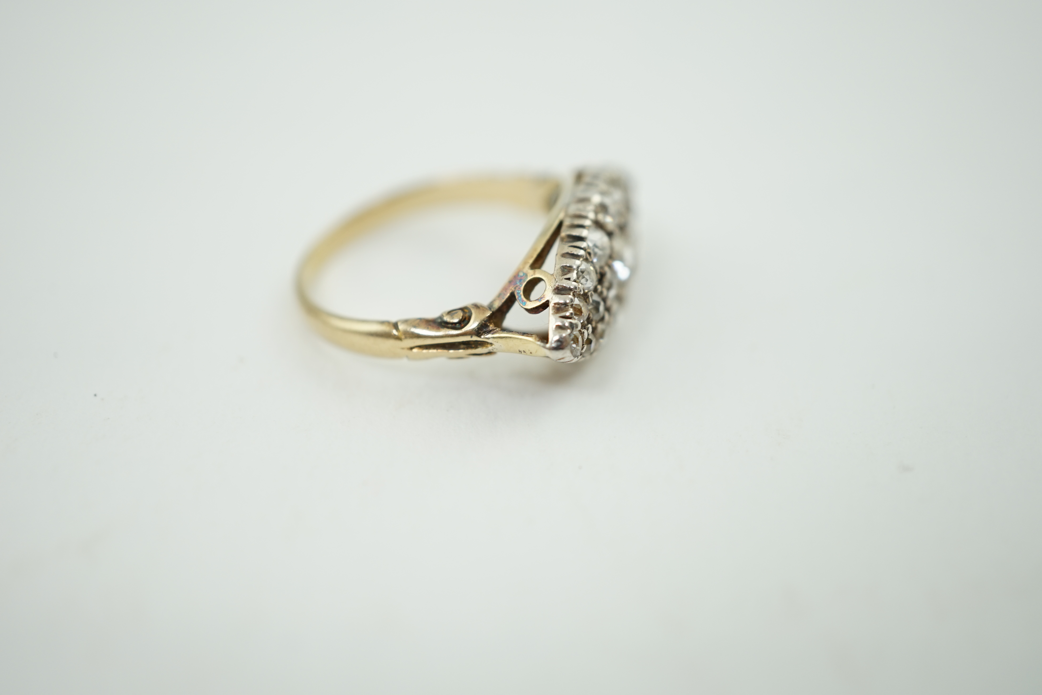 An early 20th century gold and diamond cluster set navette shaped ring